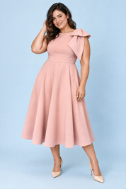 Robe midi rose à encolure asymétrique et manche à nœud | Porté sur une silhouette plus ronde | Lounelle Paris